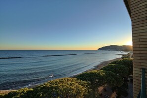 A coastal view with a clear sky, a sandy beach, and a rocky outcrop in the distance. - Hotel Mayola (San Bartolomeo al Mare)