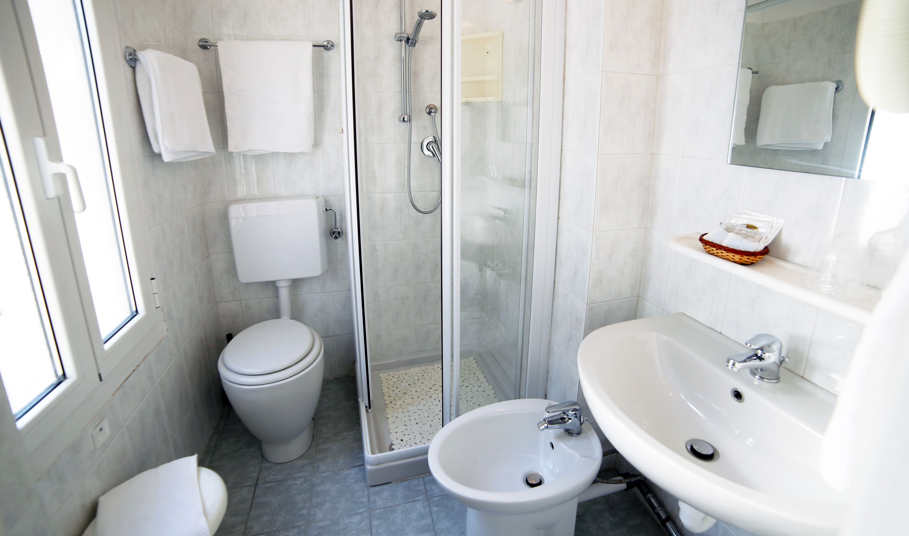 Un baño moderno con inodoro, bidé, cabina de ducha y lavabo.