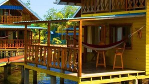 A wooden house with a balcony and a hammock. - Koko Acqua Lodge (Bocas del Toro)