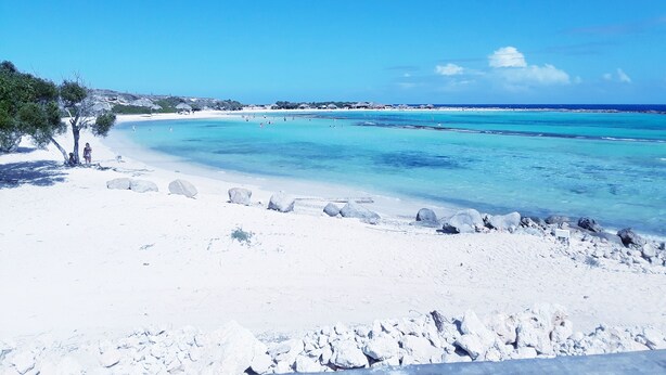 A beach with clear turquoise waters, white sand, and rocky outcrops. - Villa Amarc: Family Fun, Kite Surf, Balcony View minutes to Rodgers/Baby Beach! (San Nicolas)
