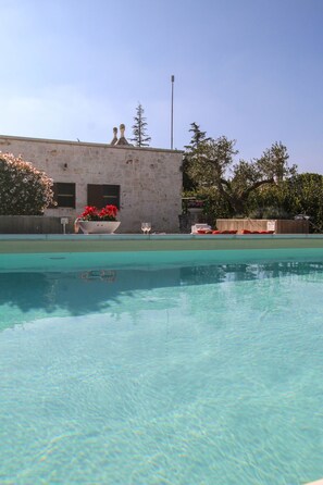Una piscina al aire libre de temporada, sombrillas