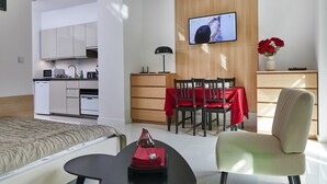 A modern hotel room with a kitchenette, a dining area, a TV, and a bed. - Praga Elegant Studio (Warsaw)
