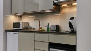 A modern kitchen with a dishwasher, microwave, and a built-in oven. - Praga Elegant Studio (Warsaw)