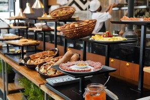 A buffet setup with various food items and baskets on tables. - Hotel Sabana Park  (Cajicá)