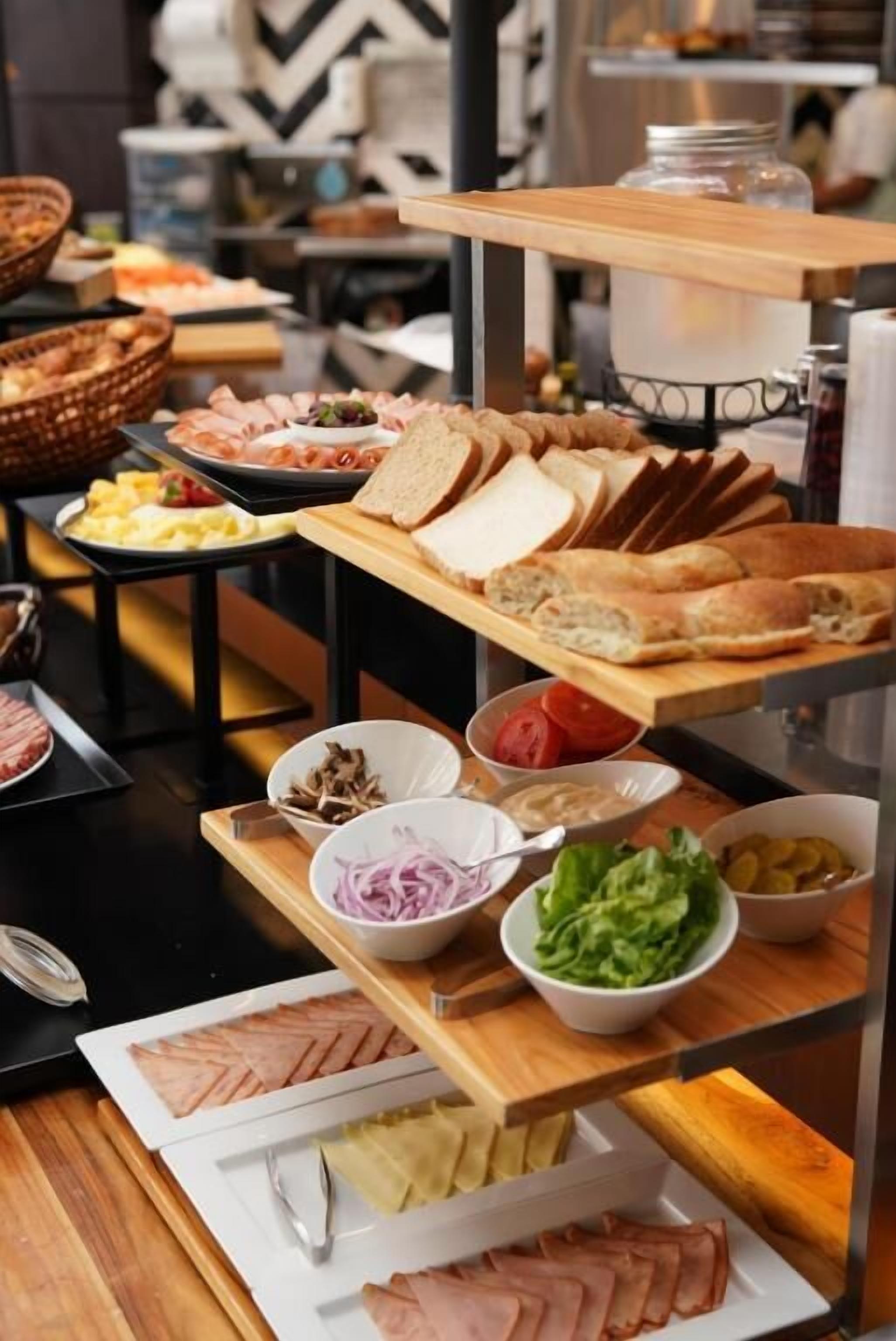 A buffet with various food items including bread, meats, and salads.
