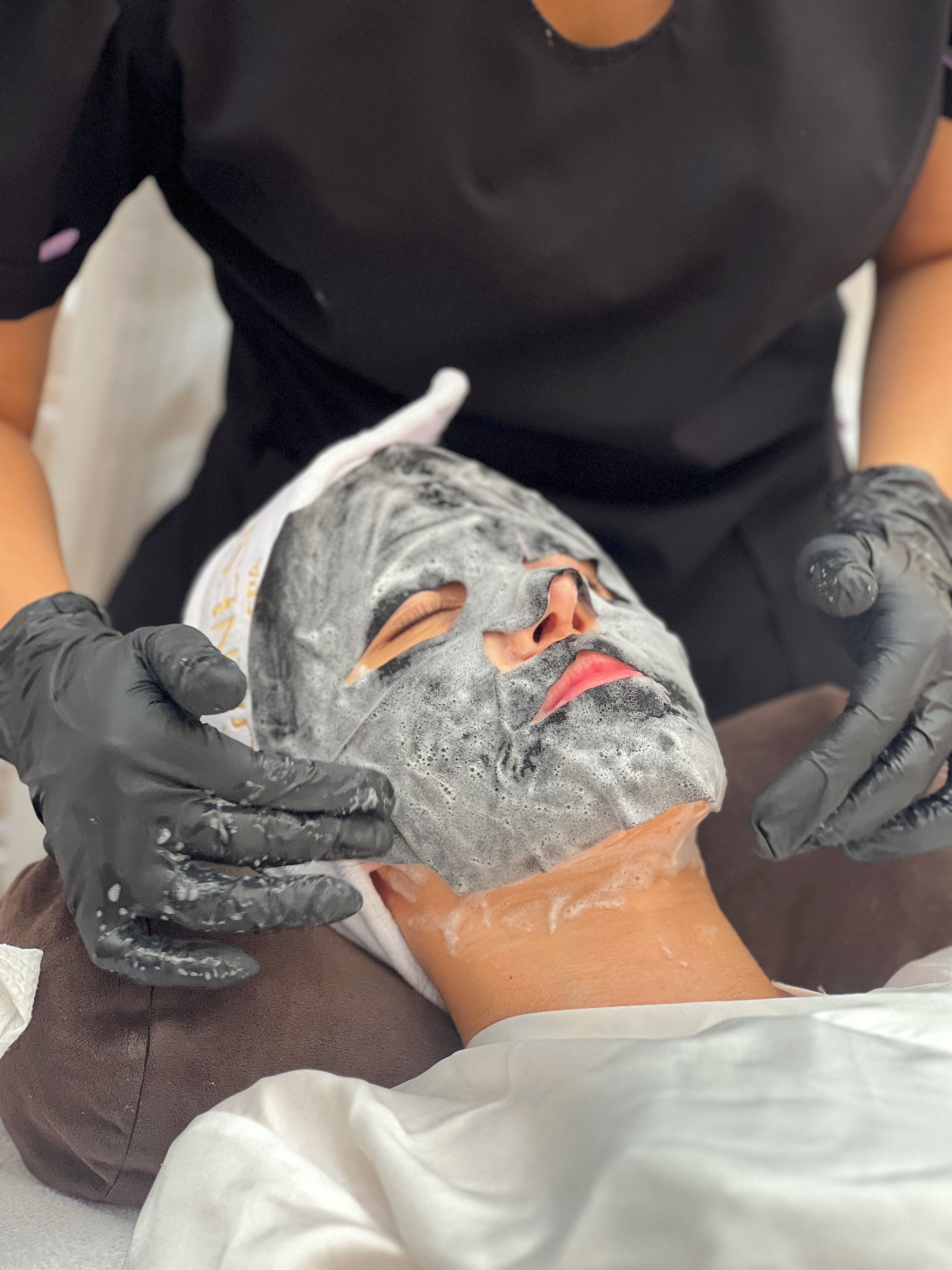 A person receiving a facial treatment with a facial mask.