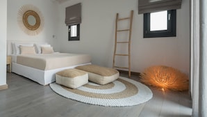 Een slaapkamer met een bed, een ronde wanddecoratie, een raam met een zonnescherm, een houten ladder en een vloerlamp.