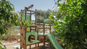 Eine Holzspielanlage mit Rutsche und Kletterelementen in einem Garten.
