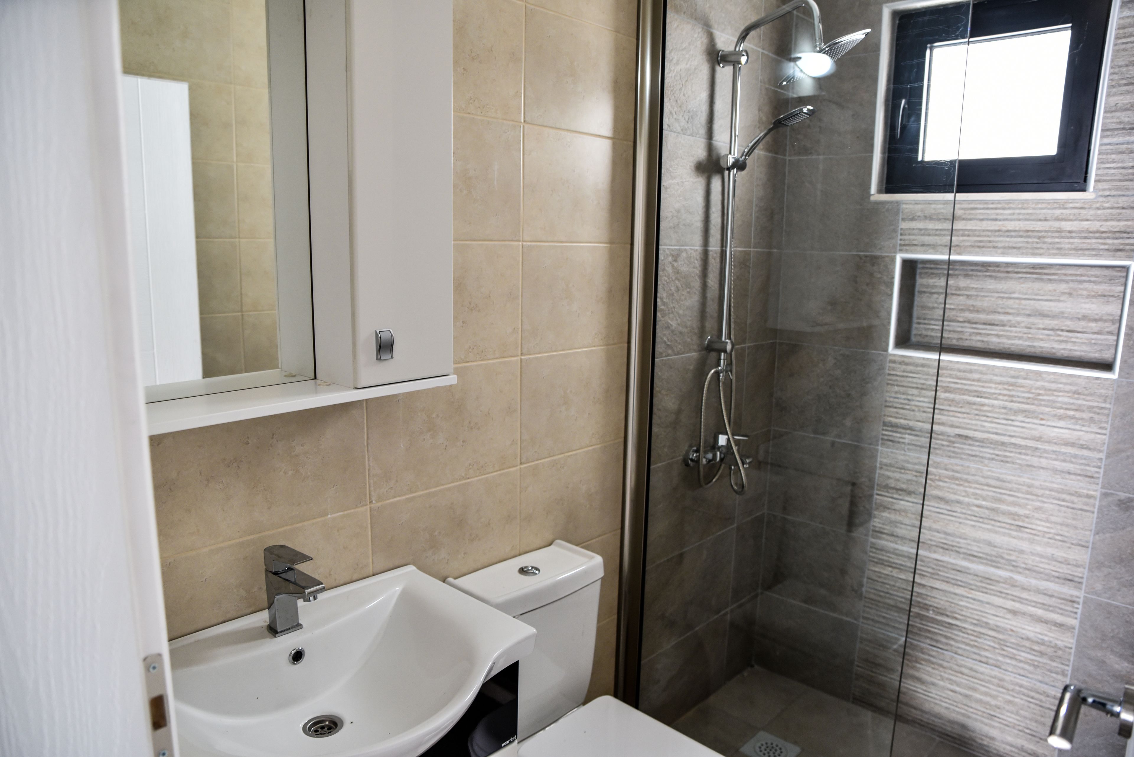 Un baño con lavamanos, inodoro y ducha.