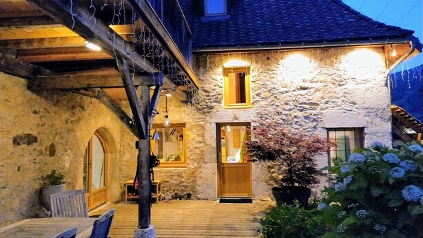 A stone building with a wooden deck, a staircase, and a potted plant. - Le ValOmbre (Saint-Pierre-de-Chartreuse)