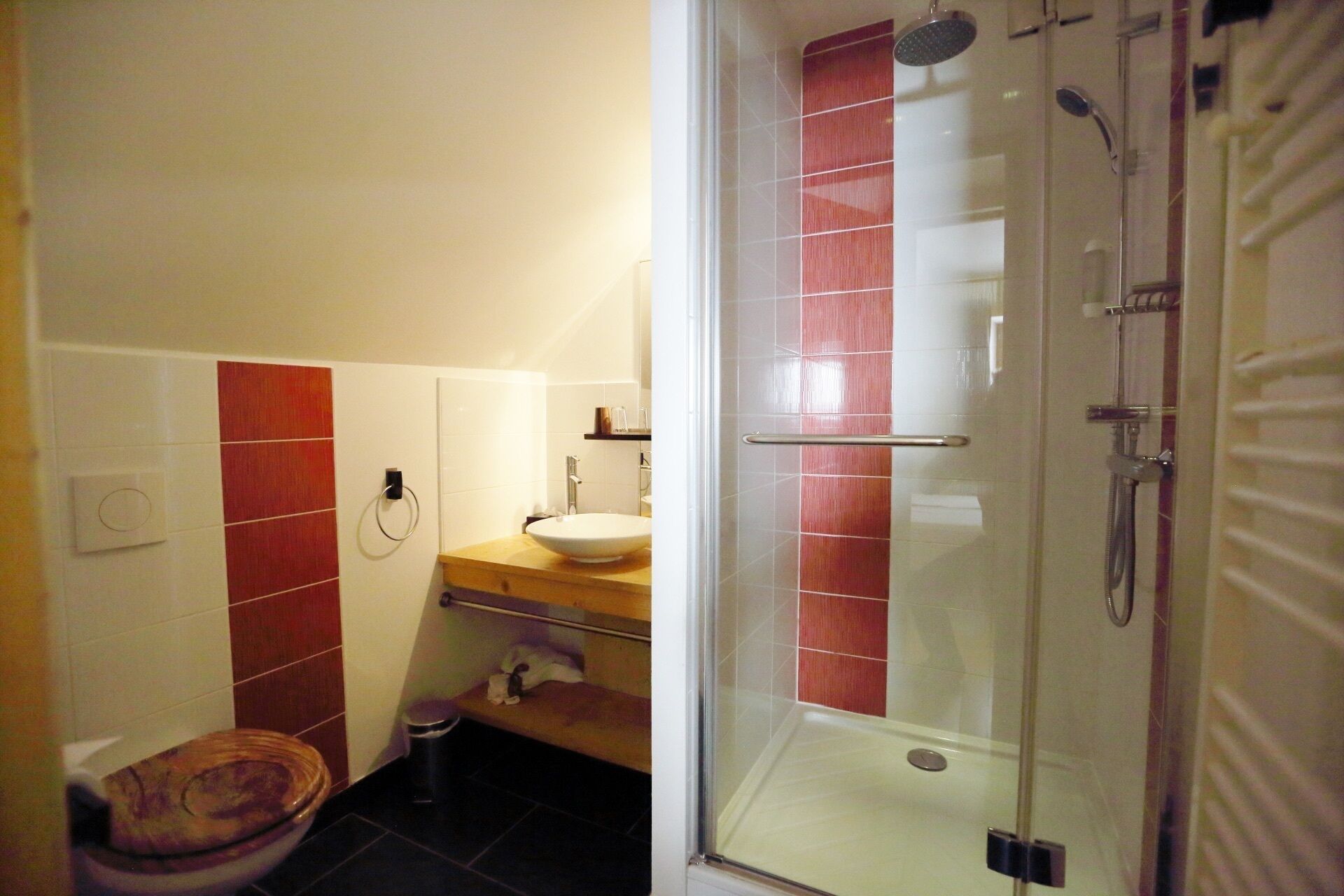 Une salle de bain comprenant des toilettes, un lavabo et un espace douche.