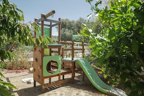 Un parque infantil con estructuras para escalar y un tobogán.