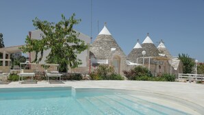 Una piscina con edificios de piedra al fondo.