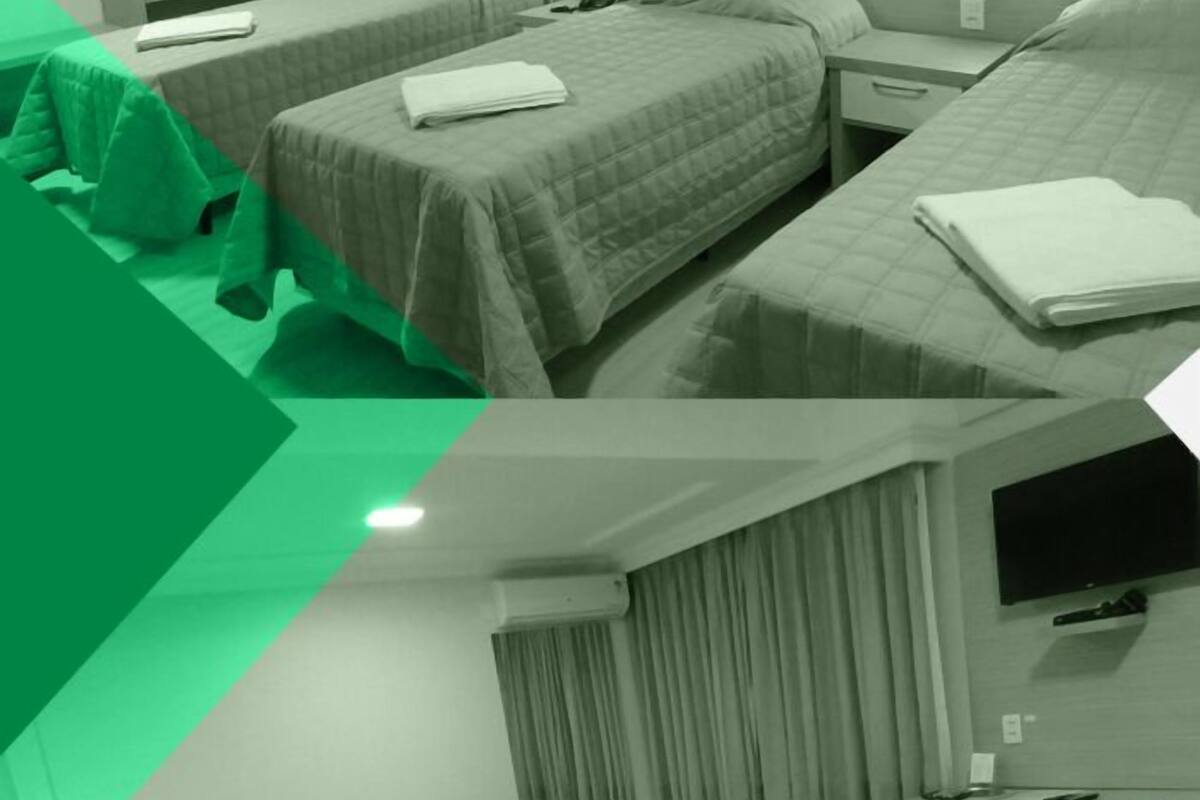 A hotel room with two beds, a desk, a TV, and a minibar.