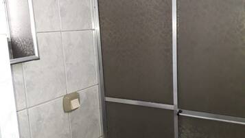A bathroom with a toilet, sink, and shower enclosure.