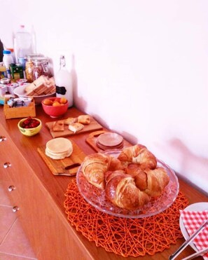 A breakfast buffet with various food items and a glass display of croissants. - B&B La Bussola (Pachino)
