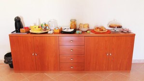A wooden buffet table with various food items and kitchen appliances. - B&B La Bussola (Pachino)