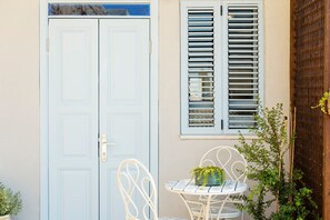 Stylish entrance with a charming table and chair, complemented by a potted plant.