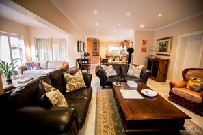 Relax in a spacious living room with a comfortable sofa, coffee table, and dining area.