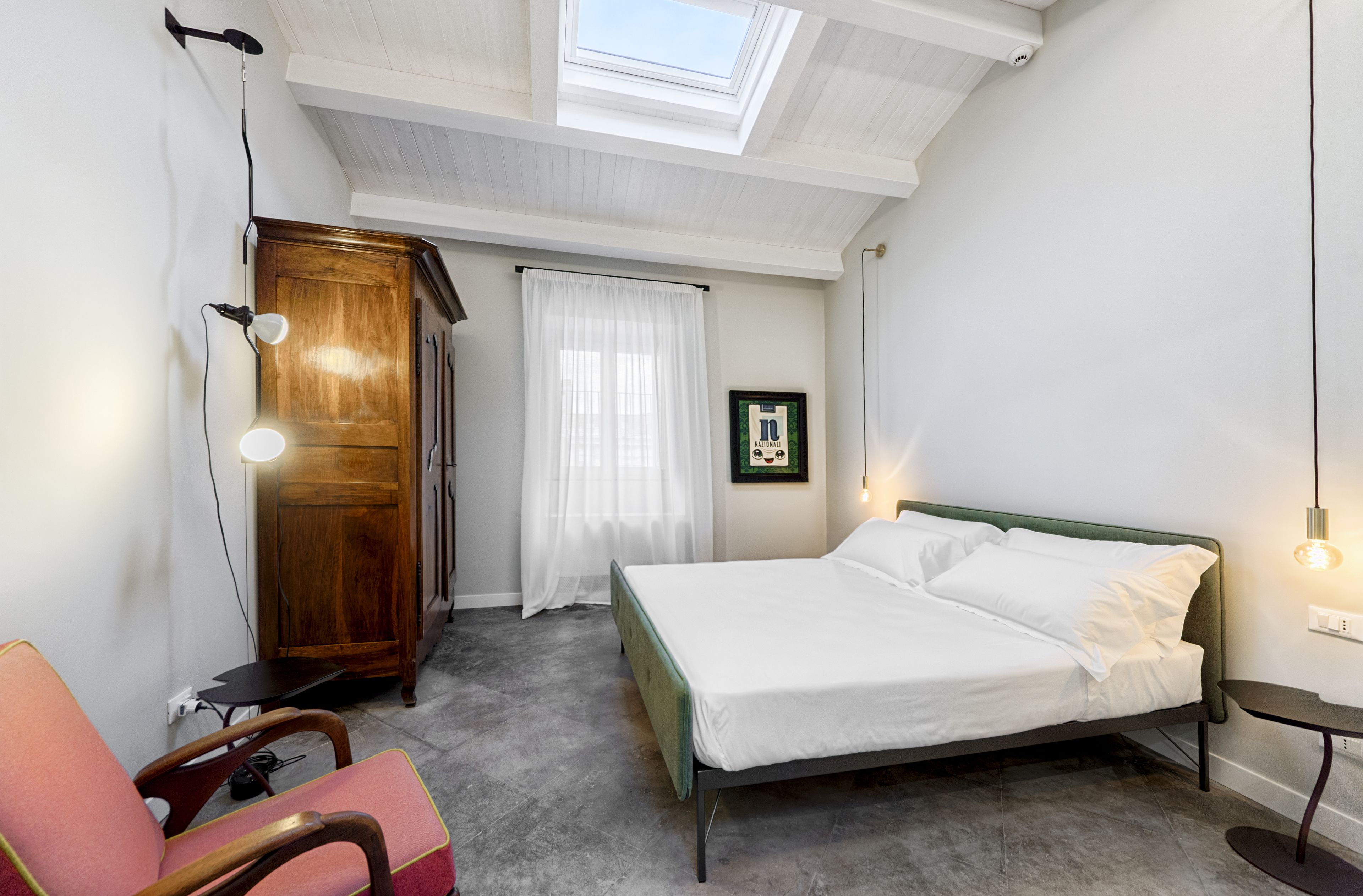 Une chambre à coucher avec un lit, une chaise, une armoire et une lucarne.