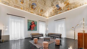 A spacious living room with dark flooring, two sofas, a coffee table, and a large painting on the wall. - a.d. 1768 Boutique Hotel (Ragusa)