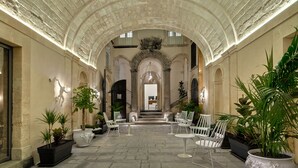 A spacious courtyard with a high arched ceiling, stone flooring, and potted plants. - a.d. 1768 Boutique Hotel (Ragusa)