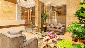 A modern lobby with a reception desk, seating area, and decorative plants. - Hotel Wego (Mumbai)