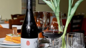 A table with a bottle of wine, tulips, and wine glasses. - Il Vecchio Frantoio (Stella Cilento)