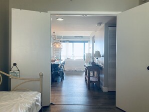 Hotellihuoneessa on sänky, työpöytä, tuoli sekä ruokailualue, jossa on pöytä ja tuoleja. Huoneessa on myös ikkuna, josta tulee luonnonvaloa.