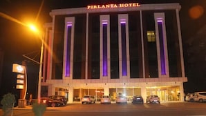 The exterior of the Pirlanta Hotel with a modern design, featuring vertical lighting accents and a prominent entrance with cars parked in front. - YZE Pirlanta Hotel (Malatya)