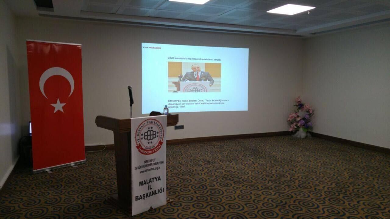 A conference room with a podium, a projection screen, and a flag.
