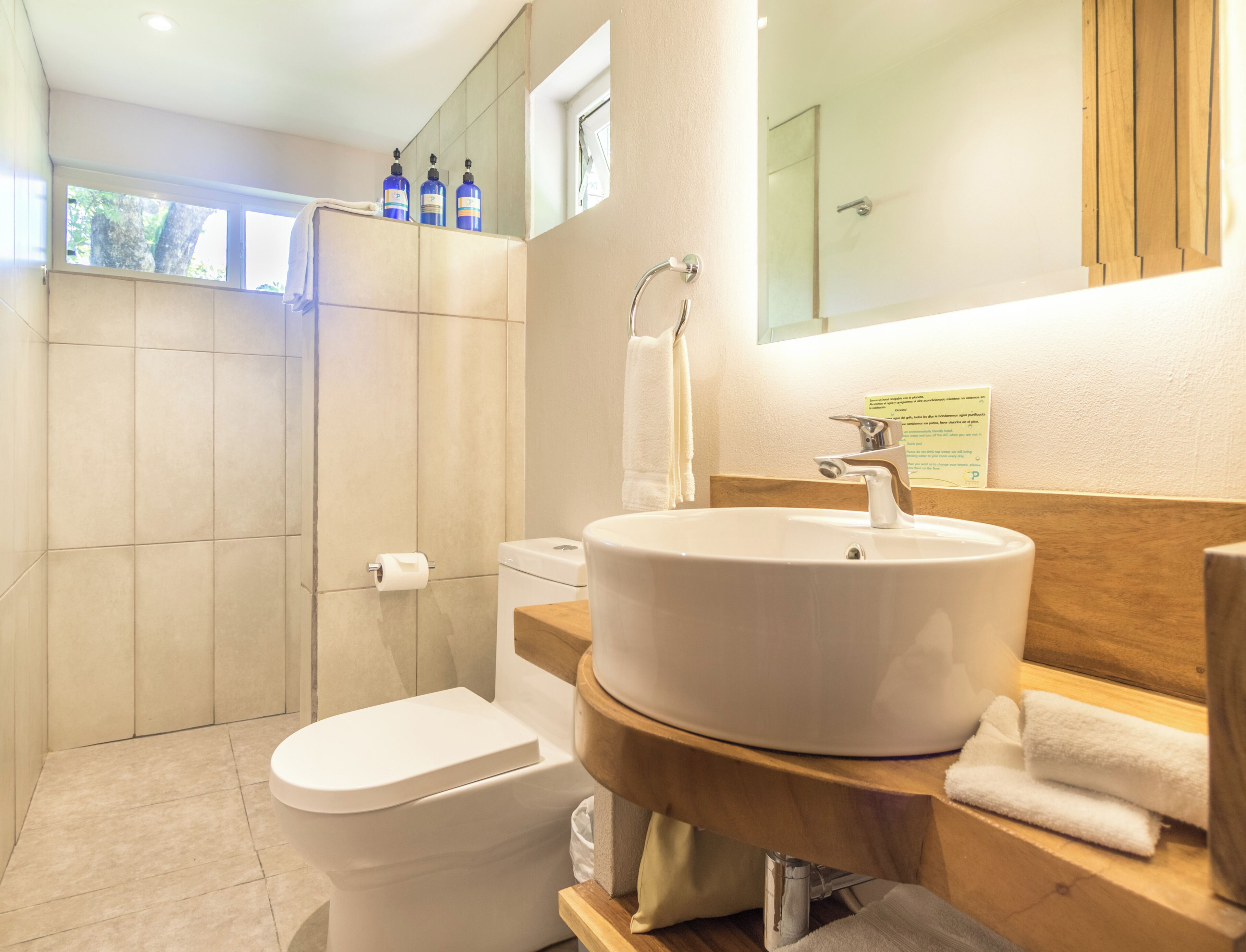 A modern bathroom with a toilet, sink, and shower.