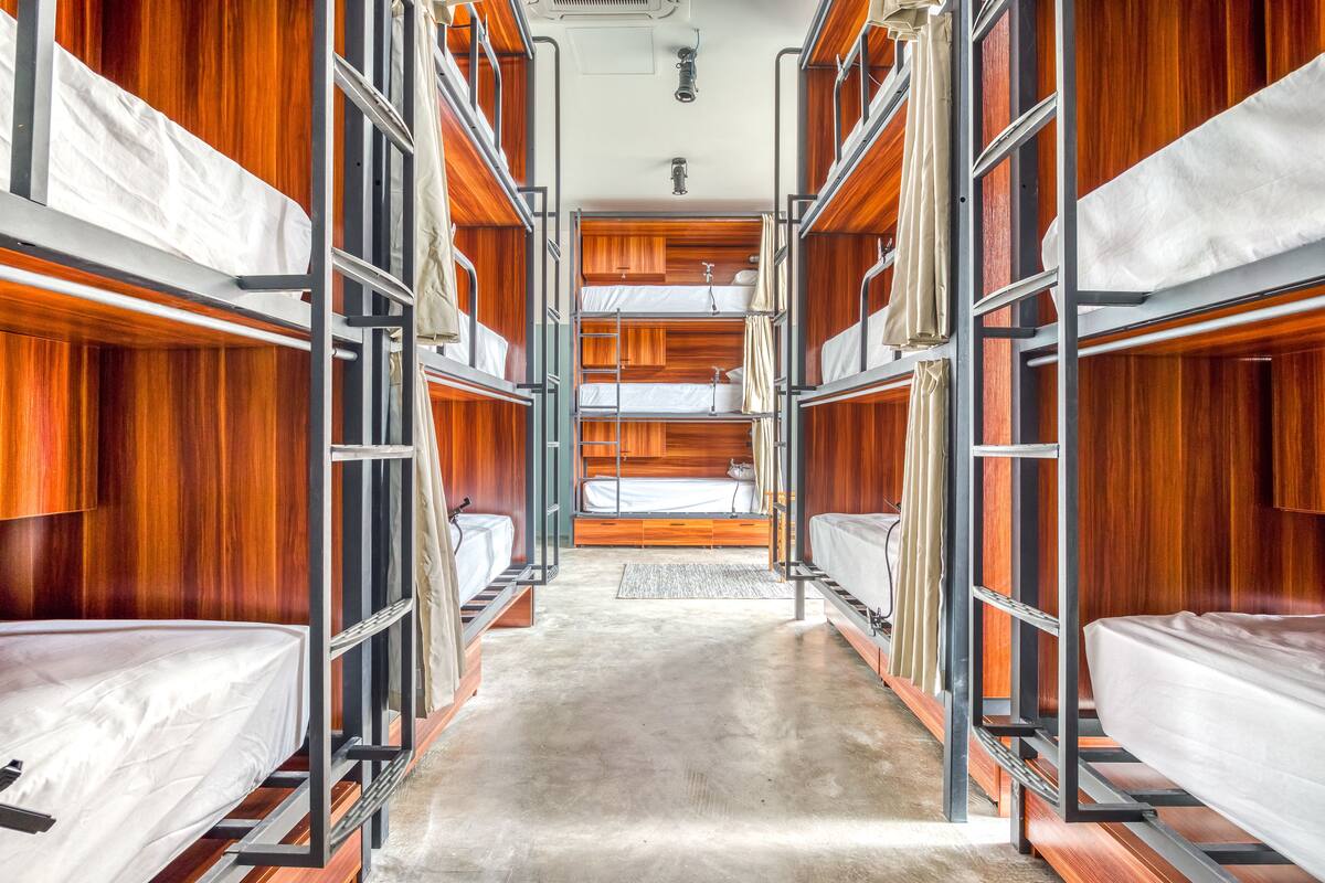 Un dormitorio tipo camarote con varias camas y paredes de madera.