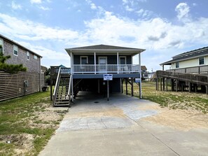 A two-story house with a covered porch and a sign indicating rental availability.
