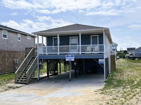 A two-story house with a balcony, a covered entryway, and a visible garage door.