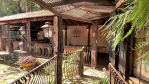 Un espace extérieur aménagé dans un style rustique, avec une pergola, des tables et des chaises en bois.