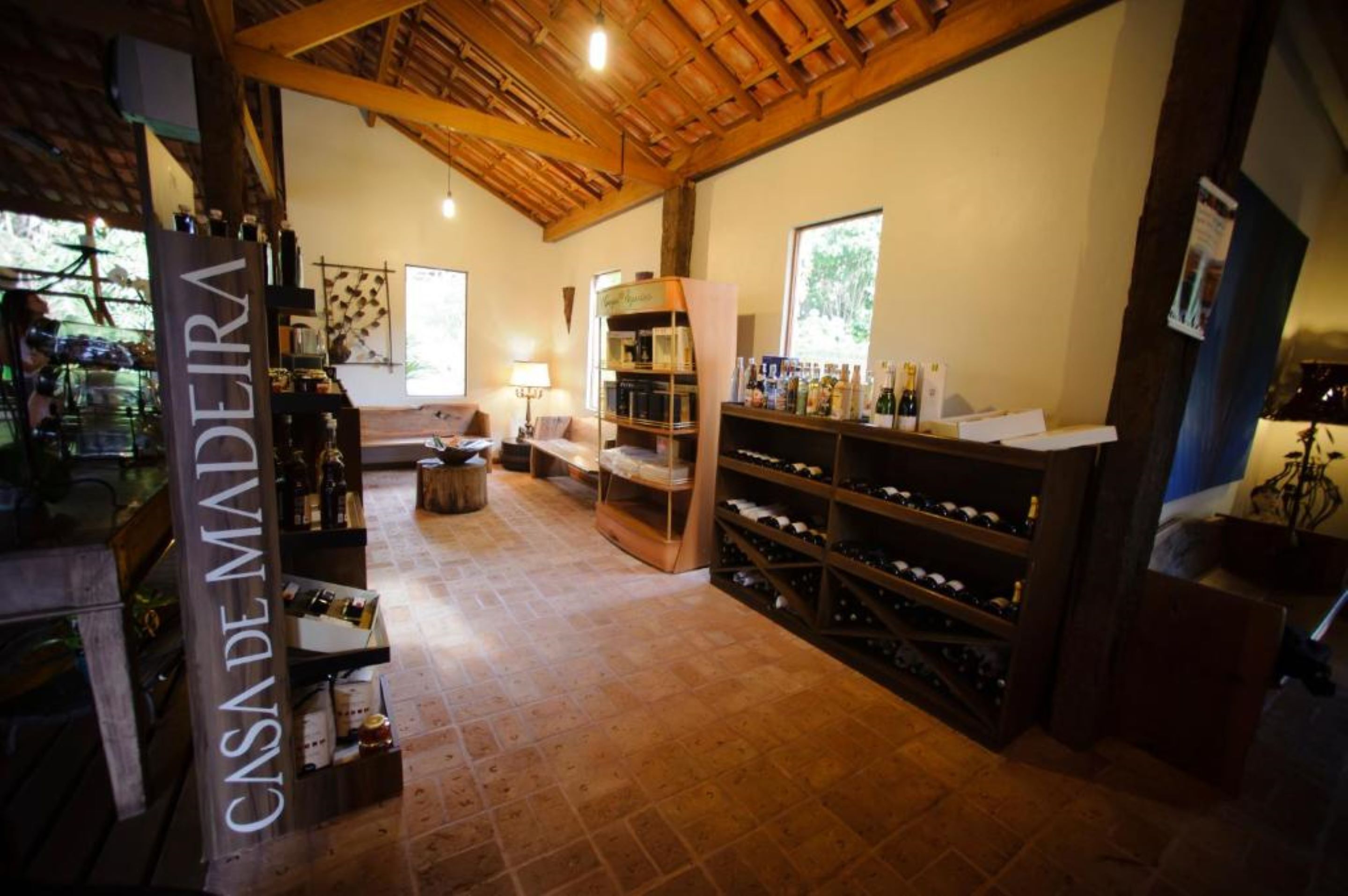 A cozy interior with a wooden ceiling, a wine rack, and a sofa.