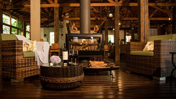 Un intérieur chaleureux avec des meubles en osier, une table en fût de bois et un téléviseur.