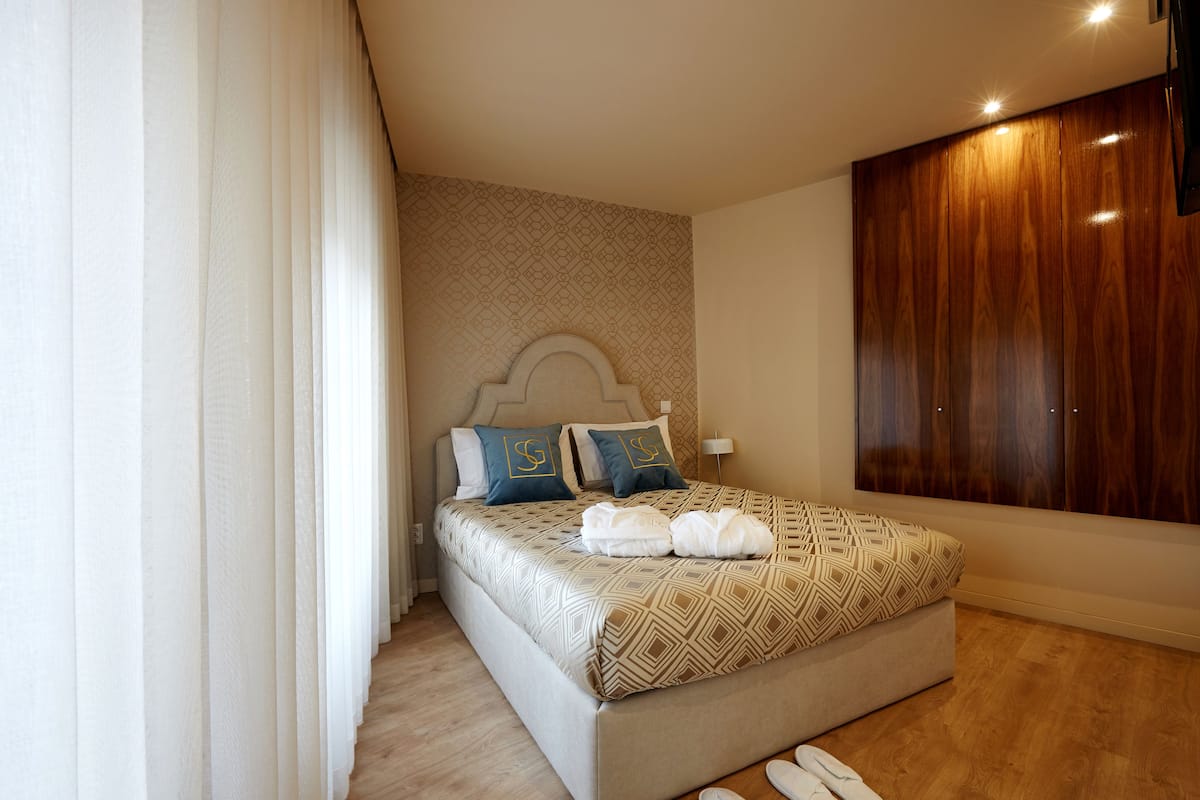 Ein modernes Schlafzimmer mit einem großen Bett, einem Holzschrank und einer Wand mit Muster.
