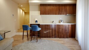 Una cocina moderna con armarios de madera, una encimera blanca y dos taburetes azules.