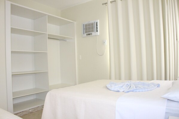 A hotel room with a bed, a wardrobe, and a wall-mounted air conditioning unit. - Thermas do Bosque (Caldas Novas)