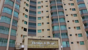 Un edificio de hotel de varios pisos con balcones y unidades de aire acondicionado.