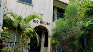 A building labeled "BJC HOUSE" with a covered entrance, surrounded by greenery and a small garden area. - Capernaum Hotels (Kampala)