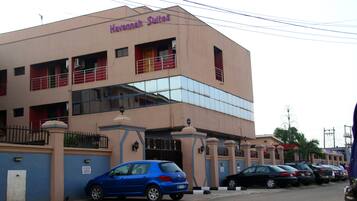 A building with a sign reading "Havannah Suites". It has multiple floors, balconies, and a gated entrance.