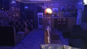 Ett svagt upplyst rum med en bardisk, sittplatser och en vägg med ett mönster.