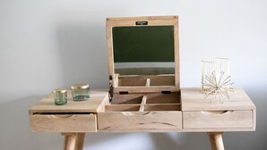 A wooden desk with a built-in laptop stand, a glass container, and a decorative metal object. - Donizetti Residence (Bergamo)