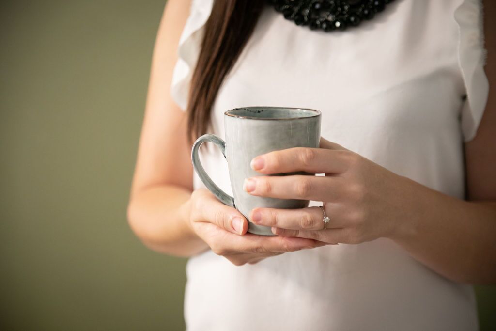 A person holding a ceramic mug.