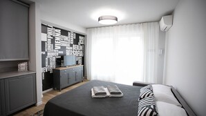 A modern hotel room with a bed, a wardrobe, a desk, and a word cloud wall. - Donizetti Residence (Bergamo)