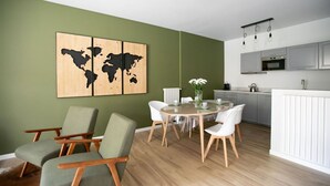 A modern kitchen with white cabinets, a central island, and a hanging light fixture. - Donizetti Residence (Bergamo)