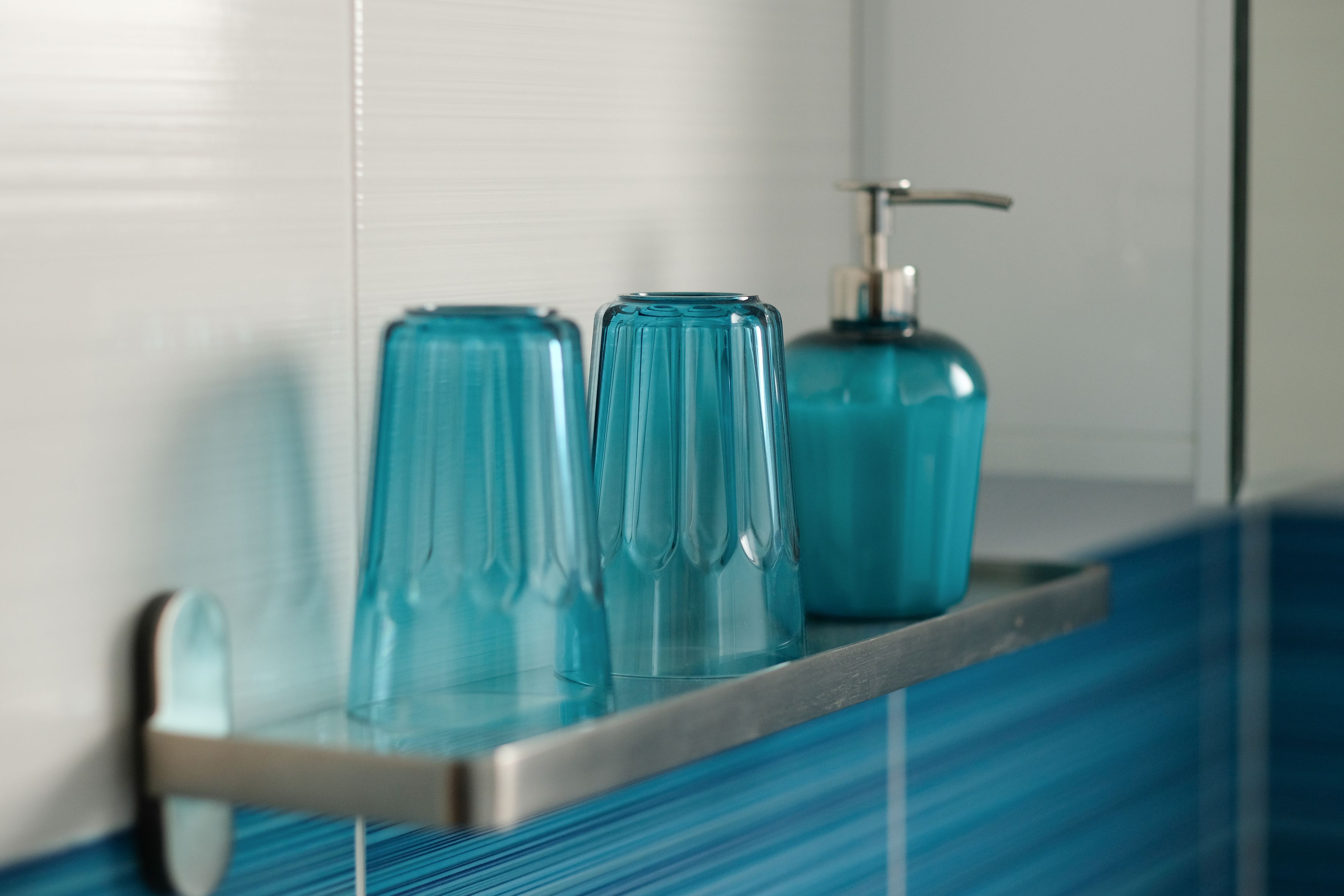 Ein Badezimmerschrank mit zwei Glasflaschen und einer Seifenspender.
